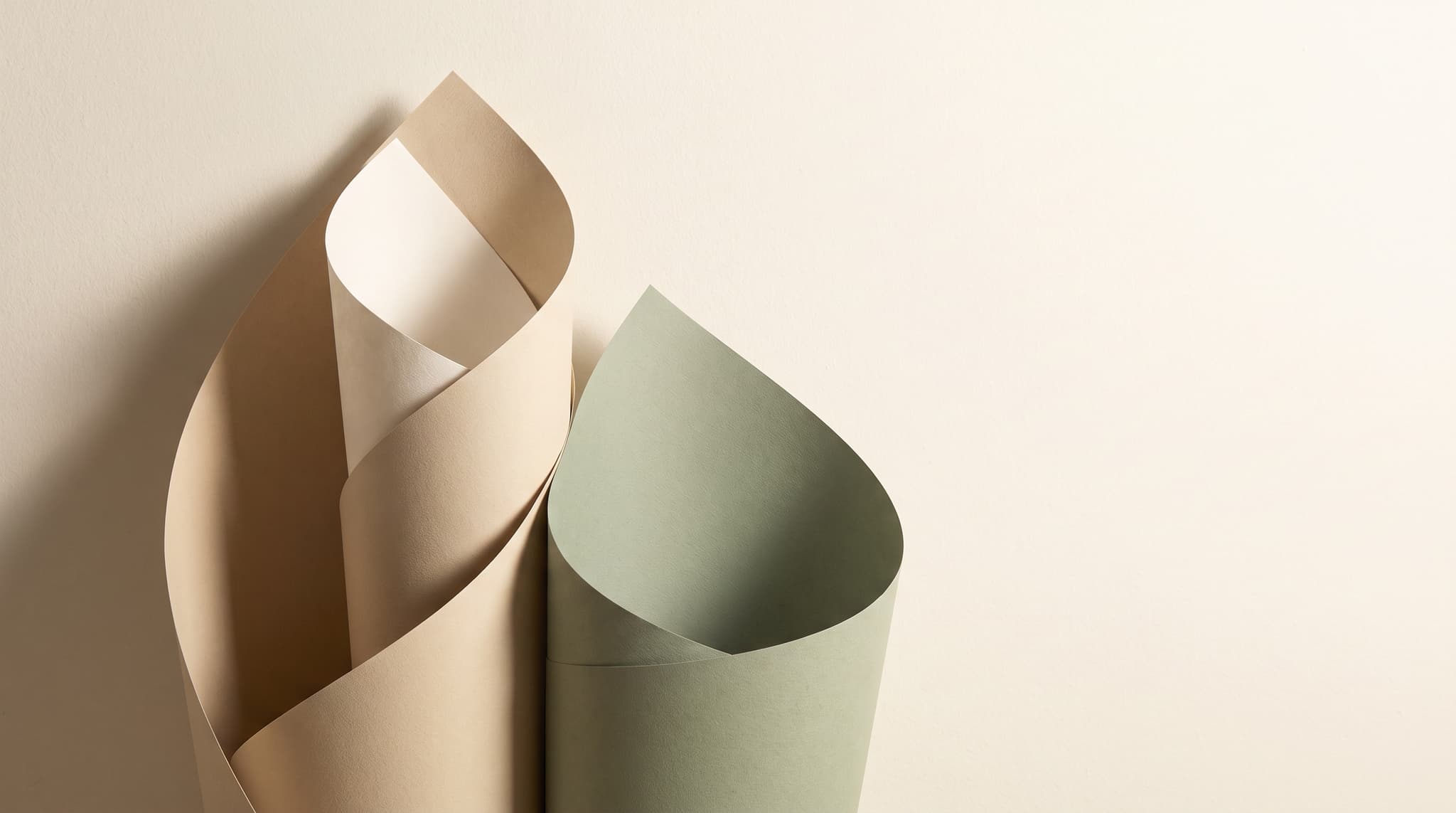 Abstract layered paper forms in soft sand and sage tones with gentle shadows