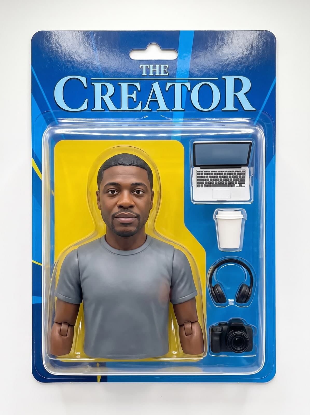 AI action figure of a man in a blister pack with a laptop, coffee cup, headphones and camera