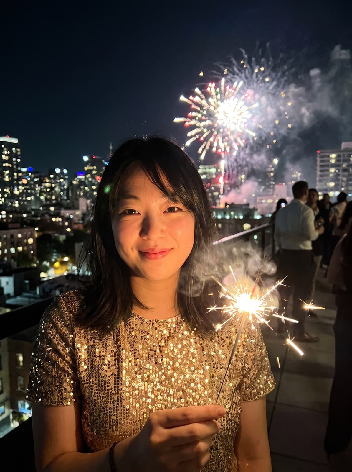 AI New Year's Eve portrait of a woman in gold sequins holding a sparkler with fireworks behind her