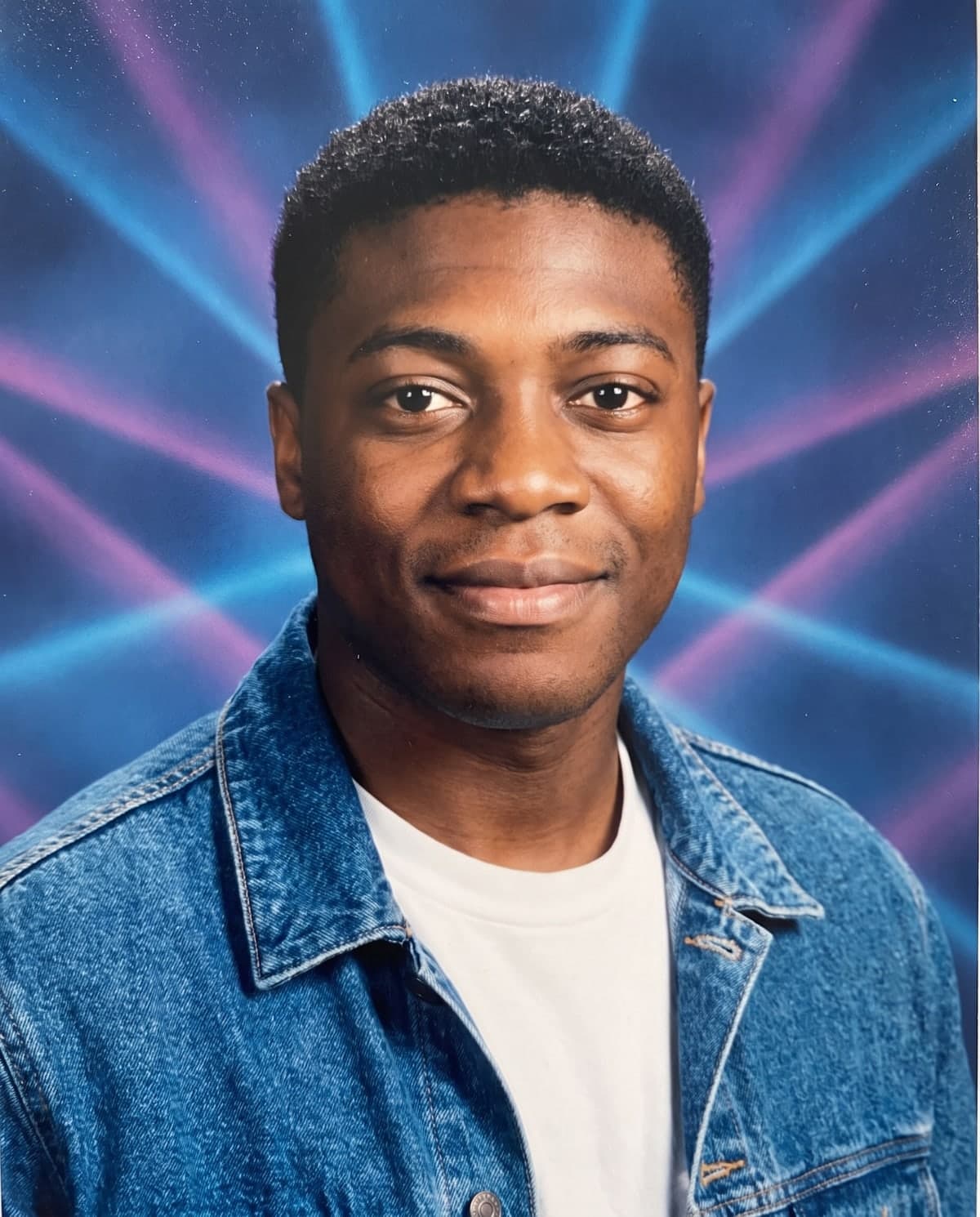 AI 90s yearbook photo of a man in a denim jacket in front of a laser background