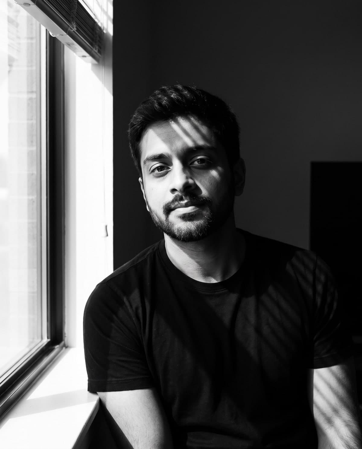 AI black-and-white portrait of a man with striped window-blind shadows across his face